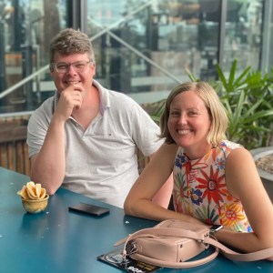 Stuart Low Low with his wife and dive buddy, Sally, sitting at a table in Fiji, smiling.